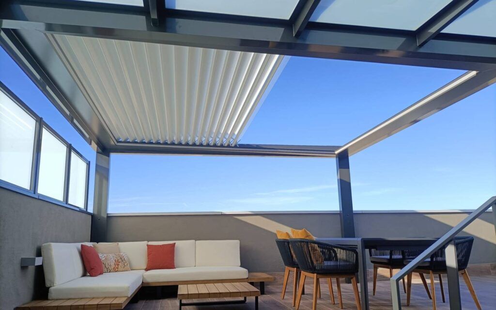 Pérgola bioclimática retráctil con cierre de cristal para una terraza de bar o restaurante