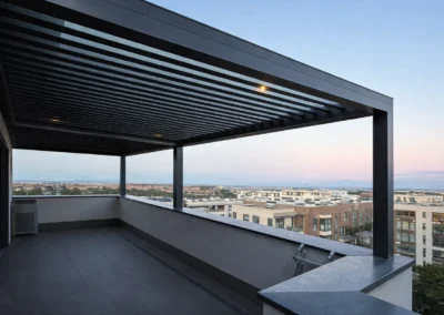 Pérgola de aluminio instalada en terraza con plantas y zona de descanso